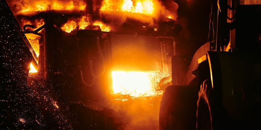 Industrial furnace interior with intense flames and sparks — representing the extreme thermal environment inside a rotary kiln burning zone