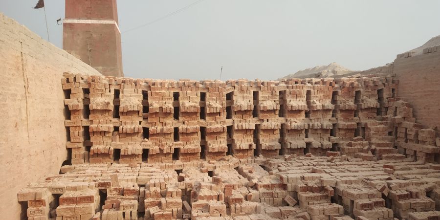 Large stacks of dense refractory bricks at a manufacturing facility — the materials that line steel industry furnaces, converters, and ladles