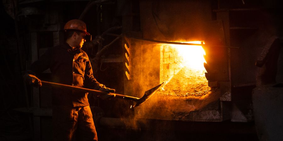A worker managing a furnace in an industrial plant — the working lining choice between brick, castable, and ceramic fiber depends on load and chemistry