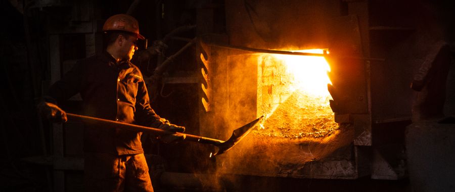 Worker managing a furnace in an industrial plant — industrial furnaces rely on correctly specified refractory fire bricks for campaign life measured in years