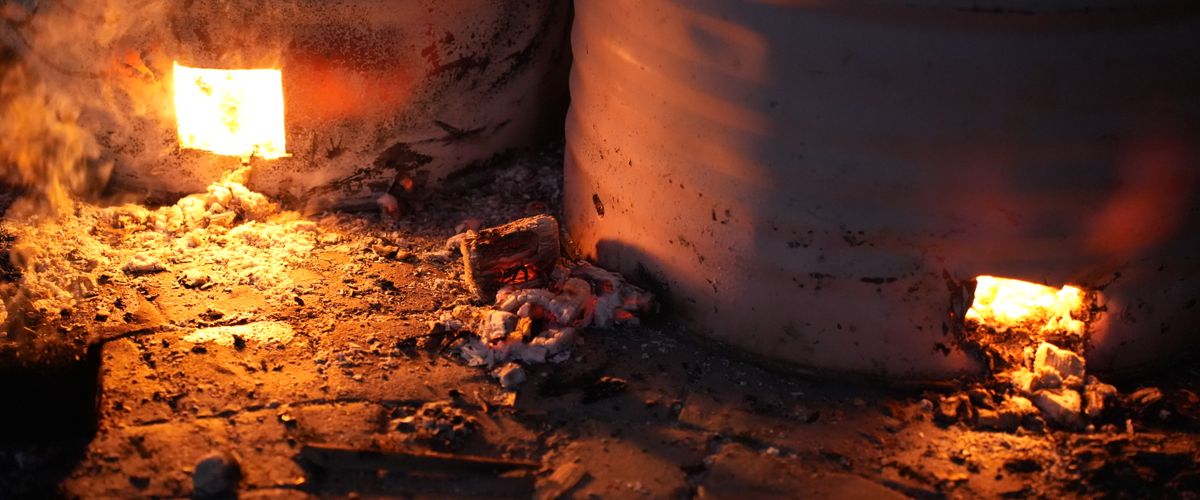 Glowing refractory kiln interior showing intense heat through brick openings — the operating environment refractory bricks are built for