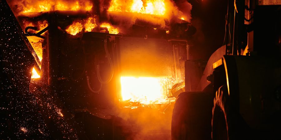 Industrial furnace interior with intense flames and sparks — representing the extreme thermal environment inside a rotary kiln burning zone
