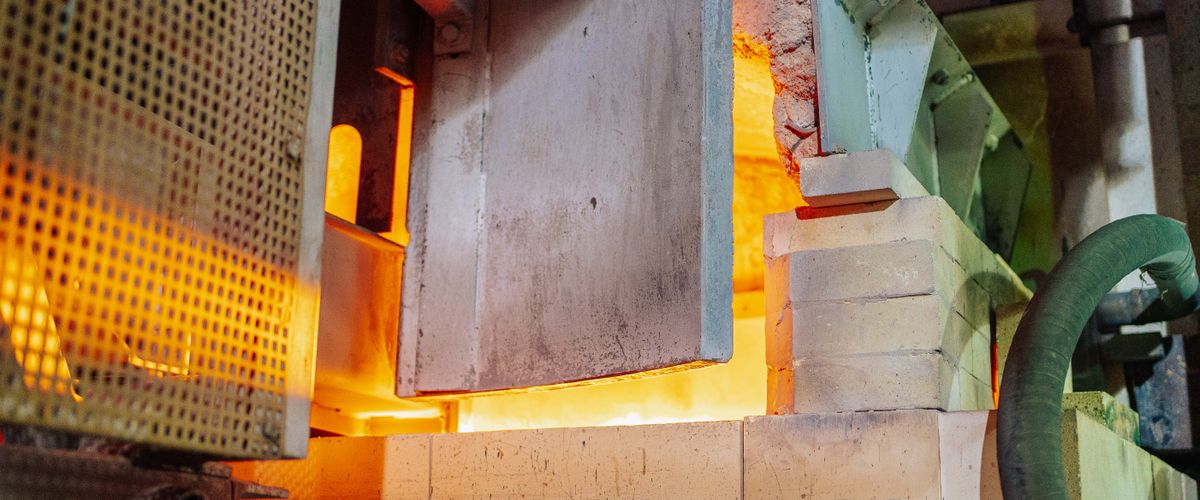 Close-up view of a working glass furnace in an industrial setting — exactly the environment insulating refractory bricks are designed to protect