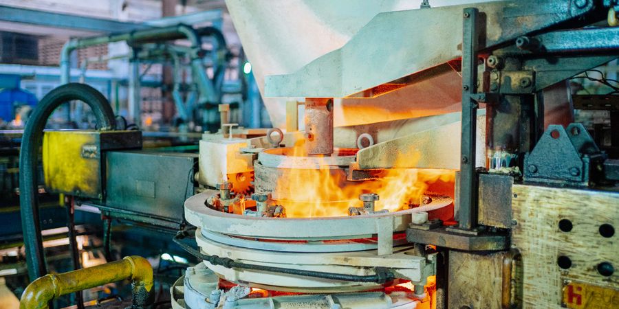 Fiery glassmaking process in an industrial factory showing the intense working conditions that determine refractory brick selection and service life