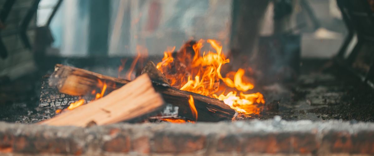 Captivating fire burning in a rustic outdoor brick fireplace — the firebox lining determines how long this structure survives