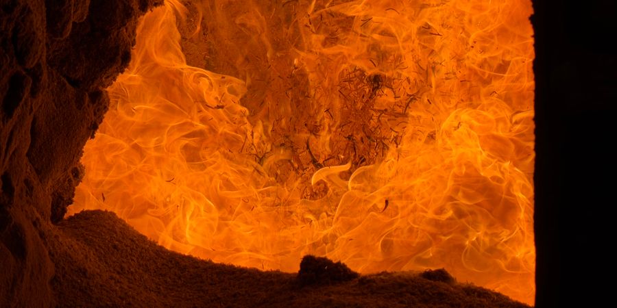 Intense orange flames inside an industrial refractory-lined furnace — showing the operating environment these ceramic bricks must endure