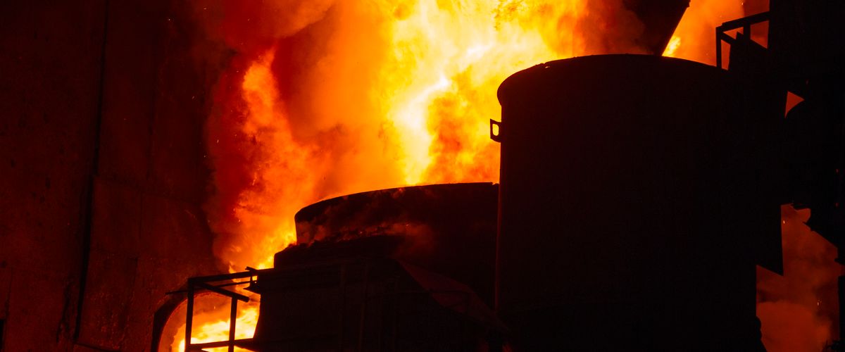 Blazing industrial furnace interior with intense white-orange flames — the operating environment refractory bricks for the steel industry must withstand